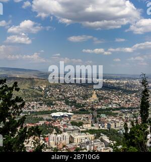 Cityscape of Tbilisi, Georgia as viewed from Mtatsminda View Point. The Holy Trinity Cathedral of Tbilisi is a prominent landmark. Stock Photo