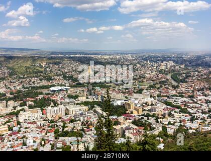 Cityscape of Tbilisi, Georgia as viewed from Mtatsminda View Point. The Holy Trinity Cathedral of Tbilisi is a prominent landmark. Stock Photo