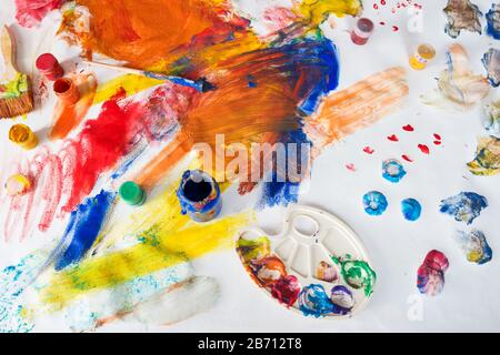 Bright multi-colored childrens drawings with paints, brushes and palette stained with paint Stock Photo