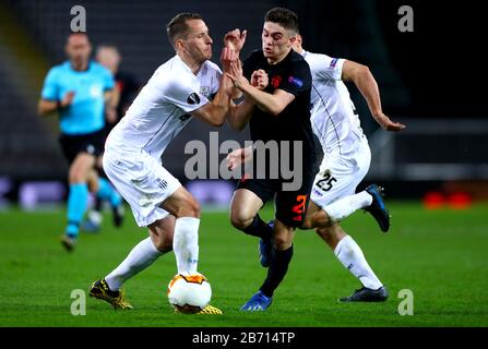 Manchester United's Daniel James (centre) ans LASK Linz's Christian Ramsebner (left) battle for the ball during the UEFA Europa League round of 16 first leg match at Linzer Stadion, Linz. Stock Photo