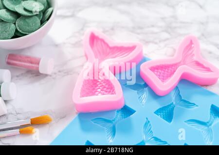 Flat lay. Ingredients to make chocolate mermaid molds from the chocolate chips. Stock Photo