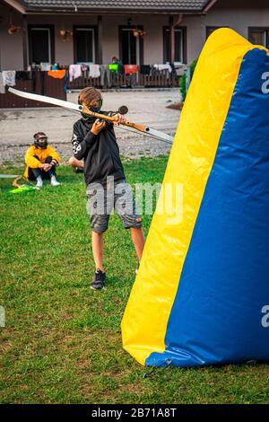Boy attacking his opponent in a game of archery tag