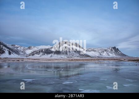 Frozen lake with snow covered mountains in Iceland Stock Photo