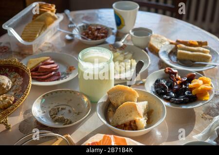Uncleaned dining table with plates, mugs and food. Stock Photo