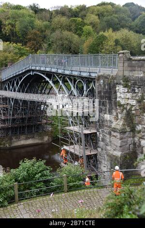 Portrait image of workmen putting up scaffolding on the famous Iron Bridge over the River Severn in Ironbridge in Telford, Shropshire UK Stock Photo