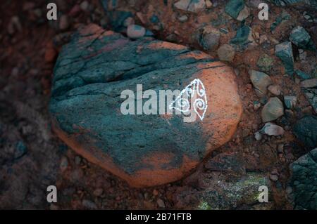 Painted boulder on the beach at Piha, on New Zealand's north island. Stock Photo