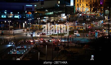 Berlin, Germany. 12th Mar, 2020. Evening view of the traffic at Alexanderplatz in Berlin Mitte. A tram crosses the Alexanderstraße. In the middle the entrance of the Park Inn Hotel is illuminated. Credit: Annette Riedl/dpa-Zentralbild/ZB/dpa/Alamy Live News Stock Photo