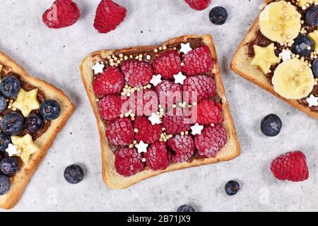 Slice of spelt toast bread topped with healthy red raspberry fruits and puffed quinoa grains Stock Photo