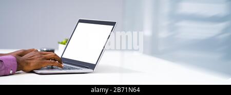 Close-up Of A Man Working On Laptop At Workplace Stock Photo