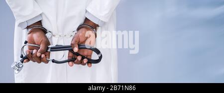 Close-up Of Doctor Hands With Stethoscope In Handcuffs Stock Photo