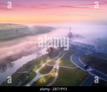 Aerial view of amazing park near river and railway bridge in fog Stock Photo