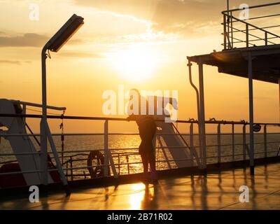 2012-08-21 Ukraina, Black sea. A man at sunset stands on the deck of a ship, looks into the distance, soft focus. Stock Photo