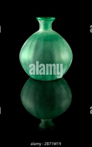 Green frosted glass vase with reflections is isolated on a black background. Stock Photo