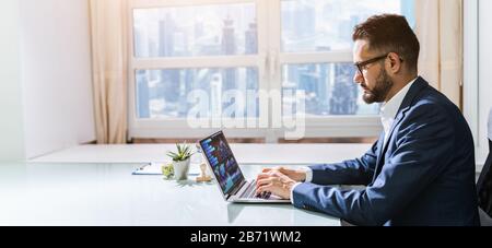 Mid Adult Businessman Working At Desk In Office Stock Photo