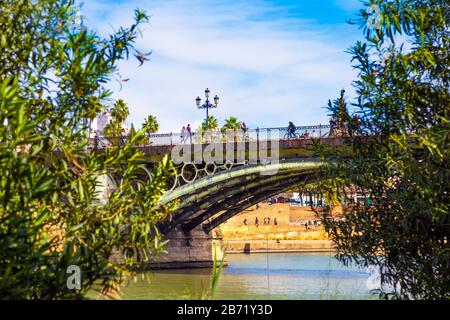 People crossing the Puente de Isabel II (Triana Bridge) Seville, Andalusia, Spain Stock Photo