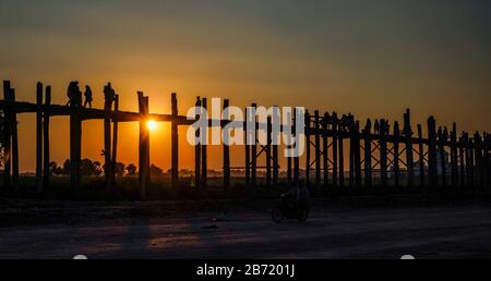 Enjoying great and beautiful sunset at U Bein Bridge in Mandalay in Myanmar while traveling in Southeast Asia in January and February 2020 Stock Photo