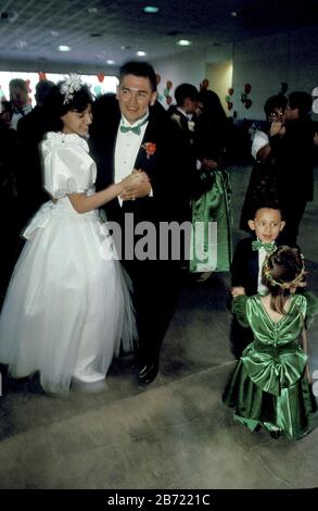 Austin Texas USA: 15-year-old Hispanic girl celebrating her quinceanera dances with her father while watching young attendees dancing together. ©Bob Daemmrich / Stock Photo