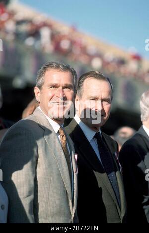 College Station Texas USA, November 26 1999: Texas Gov. George W. Bush (left) and his father, former Pres. George Bush, attend the Texas-Texas A&M college football game at the A&M campus in College Station. The game, an upset victory by the home team, was dedicated to the memory of 12 students and alumni killed two days earlier in a tragic accident when stacks of logs under construction for the annual Aggie Bonfire collapsed. ©Bob Daemmrich Stock Photo