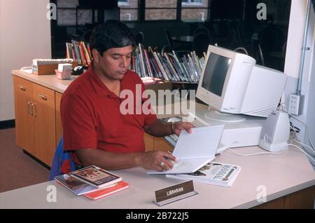 Austin, Texas USA: Male librarian working at his desk in elementary school library. ©Bob Daemmrich Stock Photo