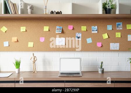 Modern workplace with laptop mock up screen sticky notes at work space interior. Stock Photo