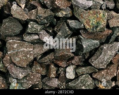 Rough stones, crushed stone, granite gravel close-up. The rough texture of the stone. Building material background. Texture. Stock Photo