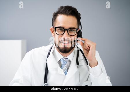 Close-up Portrait Of Confident Receptionist Using Headset In Hospital Stock Photo