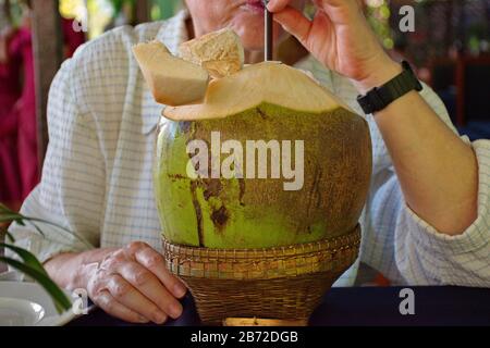 Midsection of woman juce from coconut Stock Photo