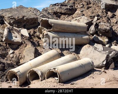 Concrete Sewer Pipes, Road Demolition Debris Pile, Road Waste, Broken Concrete, Asphalt, Tarmac, gravel, sand, aggregate, medium wide view Stock Photo