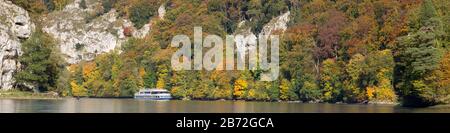 Panorama of the 'Donaudurchbruch' with a cruise ship, autumn forest and rocky landscape.  This part of the Danube is a nature reserve since 1840. Stock Photo