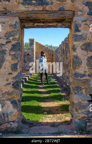 Views female tourist admiring the old Kanyaka homestead and sheep run ruins north of Quorn in South Australia. Stock Photo