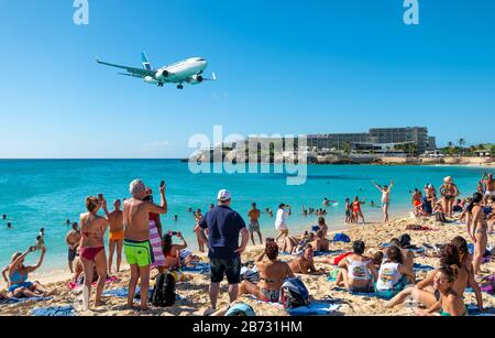 Philipsburg, St Maarten - January 27, 2019: A commercial jet approaches Princess Juliana airport above onlooking spectators on Maho beach Stock Photo