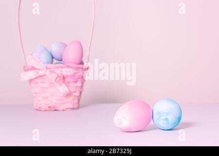 close up of pastel pink and blue Easter eggs with a pink basket in the background - Easter holidays concept image with copy space. Stock Photo