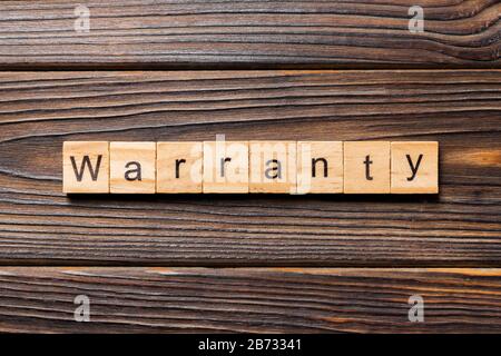 warranty word written on wood block. warranty text on table, concept. Stock Photo