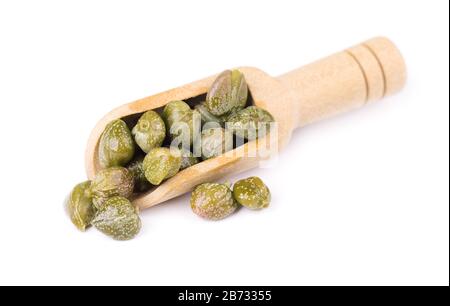 Capers in a wooden spoon, isolated on white background. Pickled capers. Canned capers. Stock Photo