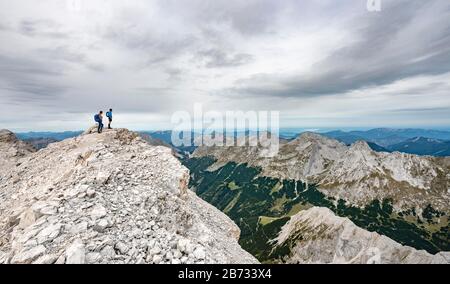 Hiker at the summit of the eastern Oedkarspitze, view of the Karwendel valley, Hinterautal-Vomper chain, Karwendel, Tyrol, Austria Stock Photo