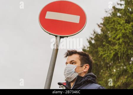 Man wearing facial hygienic mask. Ecology, air pollution car, Environmental and virus protection concept. Mask covered with toxic dust. Stock Photo