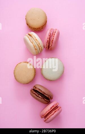 Colorful pink background with french macaroons cookies, copy space. Feminine background. Stock Photo