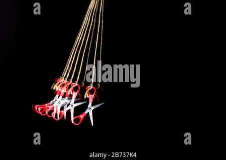 Scissors for manual work and school work, for cutting paper, cardboard, fabric, threads, twine; scissors hanging on string, multiple images of scissor Stock Photo
