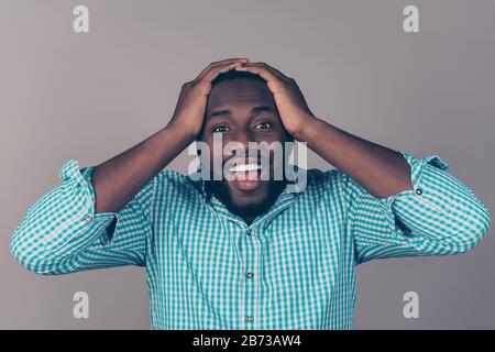 Portrait of happy excited afroamerican bearded man holding head and open mouth. Stock Photo