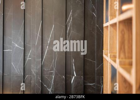 Black marble wall texture background design in pattern with blur wooden cabinet in the foreground, detailed structure of granite design for the luxury Stock Photo