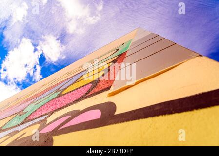 Background of a beautiful and colorful blue sky next to the decorated wall of a building. Stock Photo