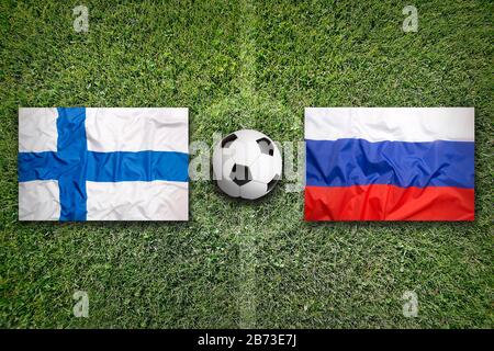 Finland vs. Russia flags on green soccer field Stock Photo