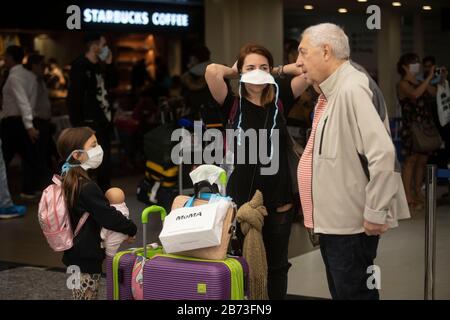 (200313) -- EZEIZA, March 13, 2020 (Xinhua) -- Passengers wearing face masks are seen at the Ministro Pistarini International Airport in Ezeiza, Argentina, March 12, 2020. In Argentina where a total of 31 COVID-19 cases have been reported, a number of sports events, including football matches, will be held without spectators, according to the country's sports ministry. (Xinhua/Martin Zabala) Stock Photo
