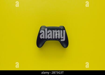 Stock photo of a black gamepad in the middle of a green background Stock Photo