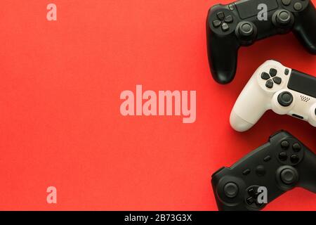Stock photo of three gamepads on a red background and copy space on the left side Stock Photo