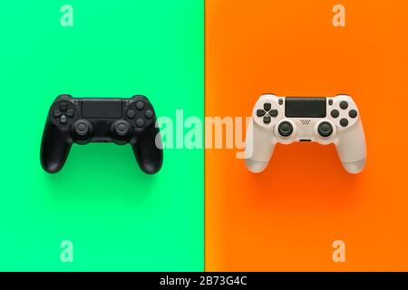 Stock photo of two gamepads in the middle of two colored backgrounds Stock Photo