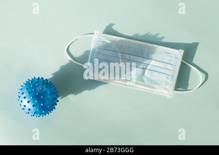 Abstract virus model of MERS-Cov or coronavirus 2019 and protective mask on blue background Stock Photo