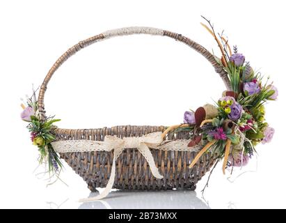 Wicker basket with original floral decor and wide ribbon isolated on a white background Stock Photo
