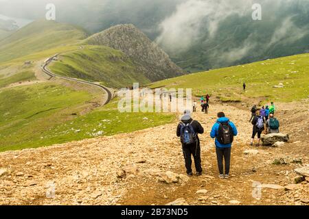 Walkers approaching Clogwyn Station on Snowdon Mountain Railway, as they descend on the Llanberis Path.  Snowdonia National Park, Wales, UK. Stock Photo