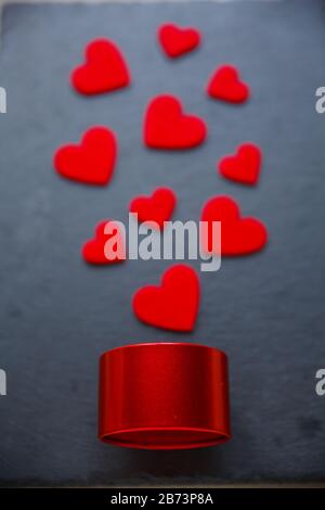 Romantic gift, concept of love. Red felt hearts and red round gift box on dark background Stock Photo
